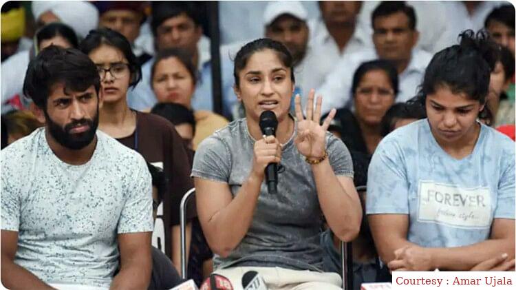 गंगा में अपना मेडल प्रवाहित कर रहे हैं पहलवान खिलाड़ी।